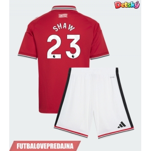 Lacne Dětský Futbalové dres Manchester United Luke Shaw #23 2026-27 Krátky Rukáv - Domáci (+ trenírky)